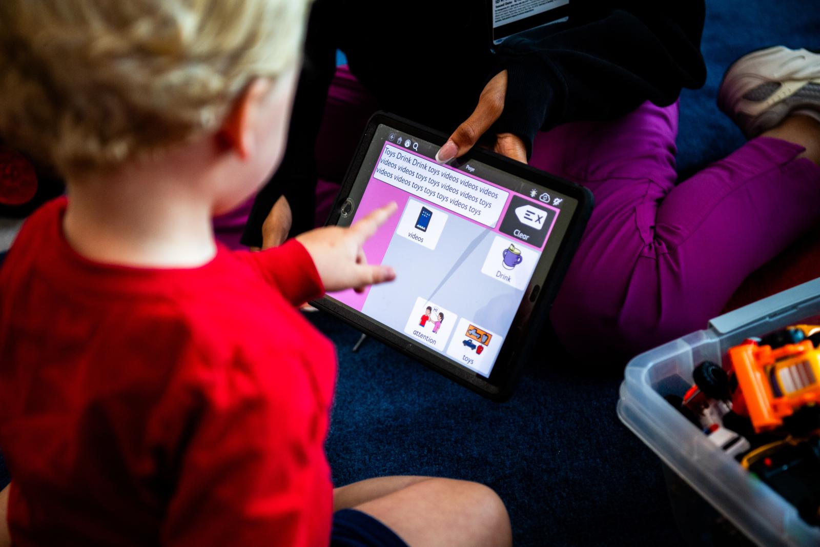 A young boy using an AAC device.